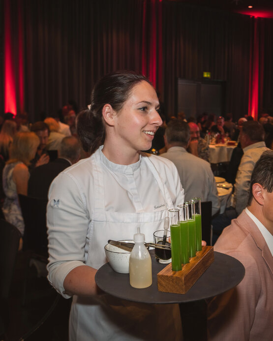 Starköchin Sandra Scheidl auf der FAFGA FUTURE NIGHT | © Florian Mitteregger Sandra Scheidl serviert die Komponenten des zweiten Gangs, mit denen die Gäste den gebeizten Saibling selbst vollenden können: Gurkensud, Holundergelee, frischen Dill und Kürbiskernöl. | © Florian Mitteregger